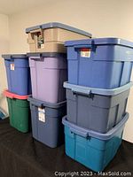 Photo showing stacked Rubbermaid storage containers in blue, purple, gray, green, teal, and tan colors with lids.