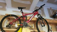 Side profile of red Mongoose 22-inch bike showing full frame, rear suspension, wheels and drivetrain.
