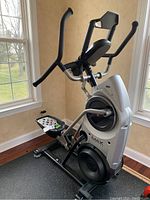 Front-side view of the machine showing foot platforms, flywheel housing and dual-action handlebars.