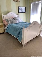 Full view of the bed frame set up with bedding for scale showing headboard, footboard, sideboards, and overall condition.
