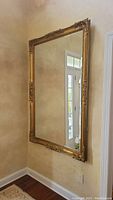 Full view of mirror hung on wall showing reflection of entryway