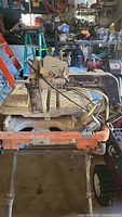 Side view of Ridgid tile saw mounted on orange plastic water tray on folding metal stand