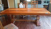 Full view of table showing plank top and carved pedestal supports