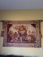 Full front view of tapestry hanging on decorative rod against yellow wall, showing overall design and colors
