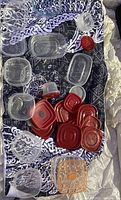 Photo of various sizes of clear plastic food storage containers and red lids