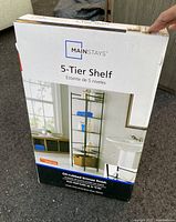 Box of Mainstays 5-Tier Shelf showing front with product image and description.