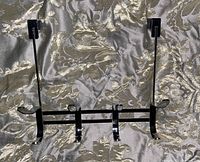 Top view of Simplify chrome over the door hook rack lying flat on fabric showing 8 hooks and door hanging brackets.