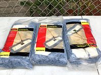 Three Rubbermaid new 24" blended dust mop heads side by side on white surface