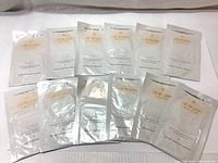 Front view of 14 Cle de Peau Beaute Soothing Moisture Mask packets arranged in two rows