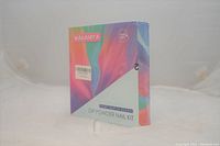 Image of the front side of the Wakaniya Dip Powder Nail Kit box showing colorful abstract design and product branding