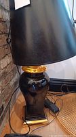 Close-up of the black ceramic lamp base with gold trim and part of the black lampshade.