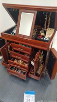 Open jewelry box showing top compartment, mirror and hanging hooks