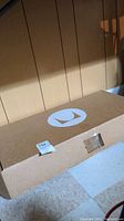 Closed cardboard box with Herman Miller logo and auction sticker