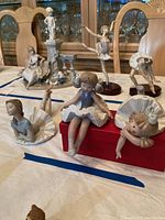 All three ballerina figurines displayed on table among other decor