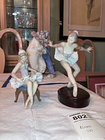 Front view of seated and dancing ballerina figurines together on table