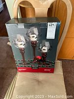 Box of 3 Pfaltzgraff Winterberry candleholders shown on a chair, box displays holly berry decorated candleholders.