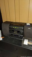 Sony stereo system with cassette player, 3 CD changer, and two detachable fabric-covered speakers seen from front.