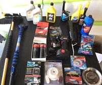 Full overview of the lot showing car fluids, brushes, tools, and accessories on black table
