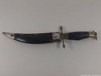 Dagger in leather sheath showing overall condition and wear of sheath and metal fittings