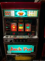 Front view of "Jack Pot" slot machine with illuminated jackpot signage, reel display and control panel.