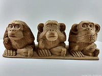 Front view of the three hand carved wooden monkeys representing "See No Evil" with distinct poses and detailed carving.