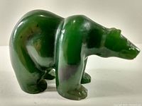 Side view of the polished green jade polar bear figurine showing its solid stance and smooth finish.