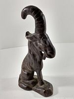 Photo of dark metal ram figurine paperweight showing detailed sculpting and integrated base.