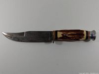 Side profile photo of Monarch Model 2141 cutting knife with stag horn patterned handle and metal blade.