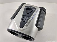 Front view of Nikon binoculars showing the lenses and Nikon logo with zoom range and specifications.