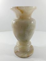 Front view of elongated onyx stone vase showing its banded coloration and shape