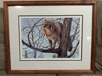Framed print showing the full artwork with the fox on a tree branch matted and under glass, with visible frame wear and wood frame.