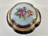 Top view focusing on the floral design and gold detailing on the rim of the trinket dish.