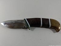 Photo of the cutting utensil showing blade and leather handle with brass guard and pommel