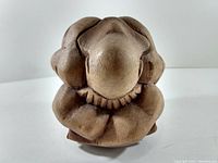 Front view of abstract wooden carving showing smooth, rounded bulbous shapes and natural wood grain.