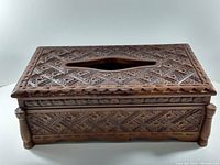 Side front angle view showing the detailed carved floral and geometric inlay design on the wooden tissue box cover.