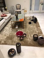 Full view of rug under coffee table with decorative items, showing overall size and condition.