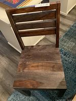 Front view of single solid walnut chair on floor rug