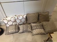 Front view of four sets of pillows arranged in two rows, showing various colors and patterns.
