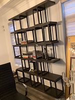 Front view of dark brown grid-style wall-mounted display unit with five staggered shelves.