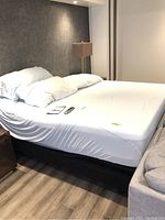 Side view of assembled adjustable bed base with mattress and bedding