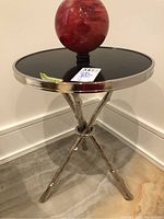 Angled view of the side table with red glass globe on top