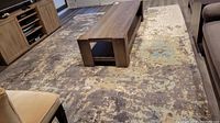 Full view of rug under coffee table showing overall abstract pattern and placement