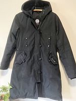Front view of black parka hanging on wall