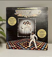 Front of the Saturday Night Fever original movie soundtrack double LP vinyl with disco floor and band image.