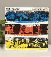 Front cover of The Police Synchronicity vinyl record with colorful band photo collage.