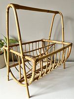 Angled view of vintage bamboo magazine rack showing handle and basket shape