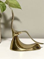 Side view of the solid brass flying seagull bookend showing its curved form.