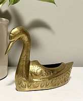 Side view of brass swan mini planter showing engraved feather details and length