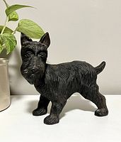 Front side view of black cast iron Scottie dog door stop, showing detailed fur texture and face.