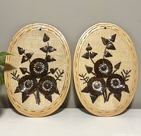 Full frontal view of both oval wooden framed floral wall decor items, showing their size and paired presentation.